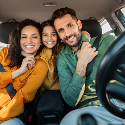 Young couple with their daughter driving in car
