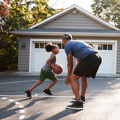 A family playing basketball in the driveway of their brand new home recently purchased with the help of St. Mary's Bank.