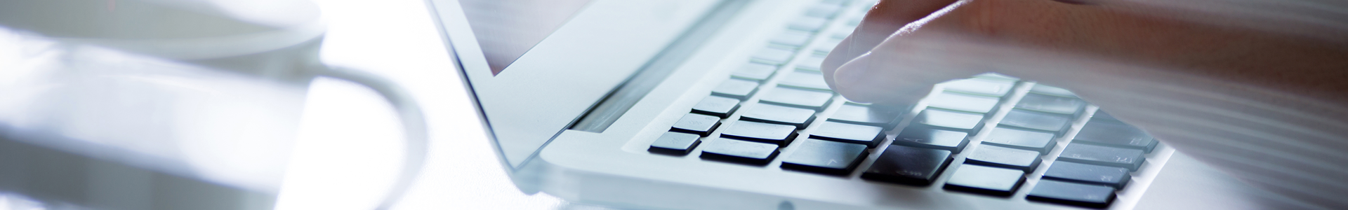 A hand typing on a keyboard of a laptop