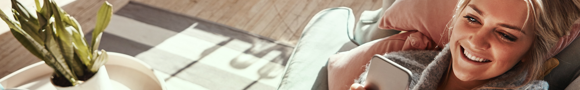 Woman lounging on a chair on her porch while browsing her mobile phone