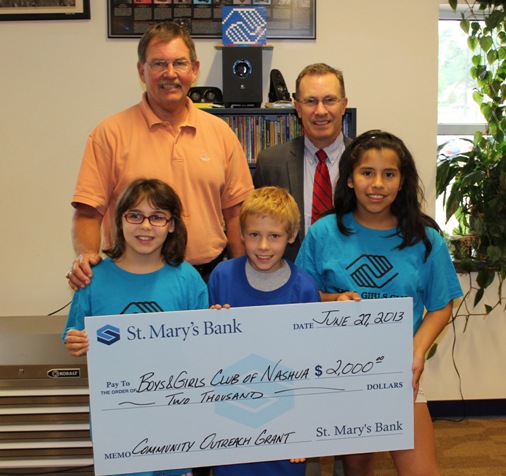 Tom Champagne of St. Mary's presents Boys and Girls Club members with check for $2000. Three children hold the check.