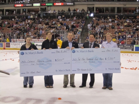 St. Mary's Bank presents two donations checks of $5000 each at the Manchester Monarchs Arena